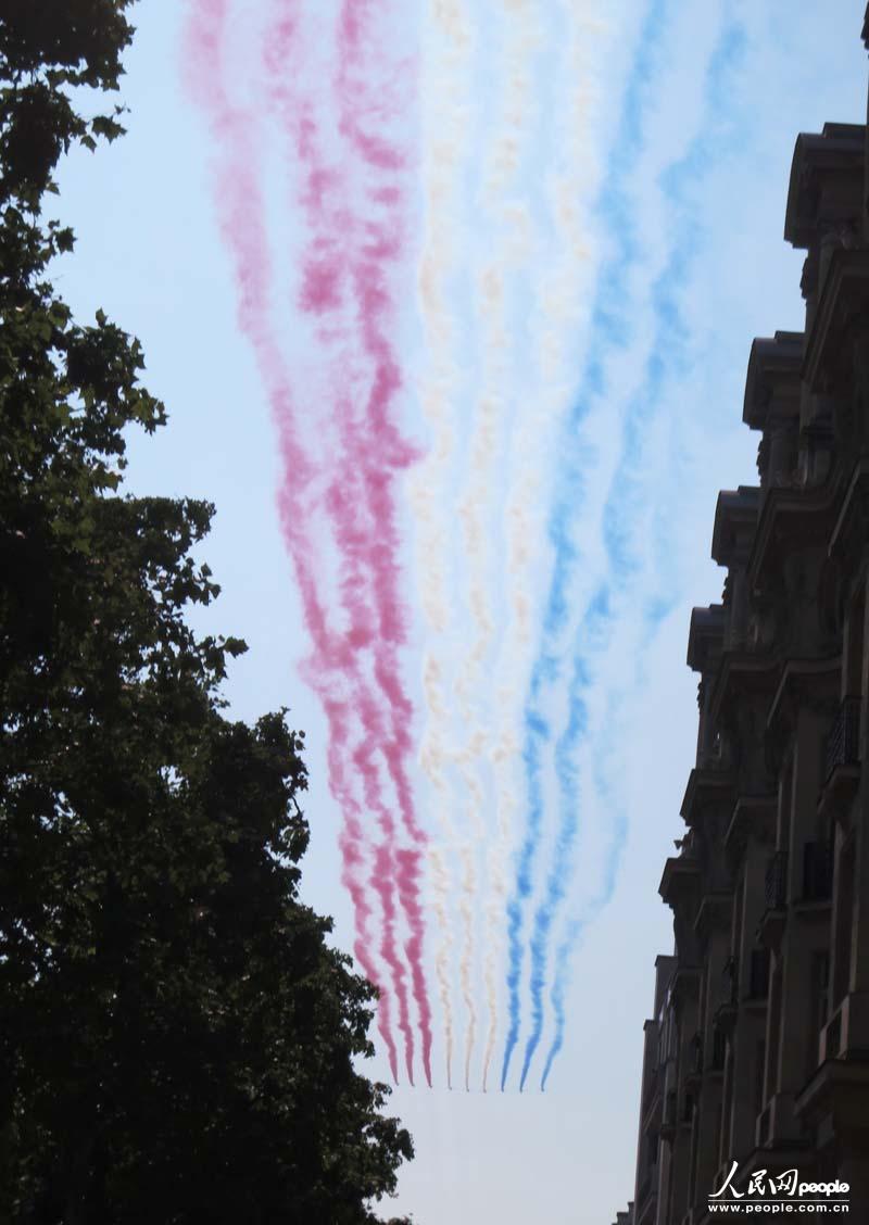 表演队用彩烟在香街上空划出法国三色旗的图案,为国庆阅兵式拉开帷幕