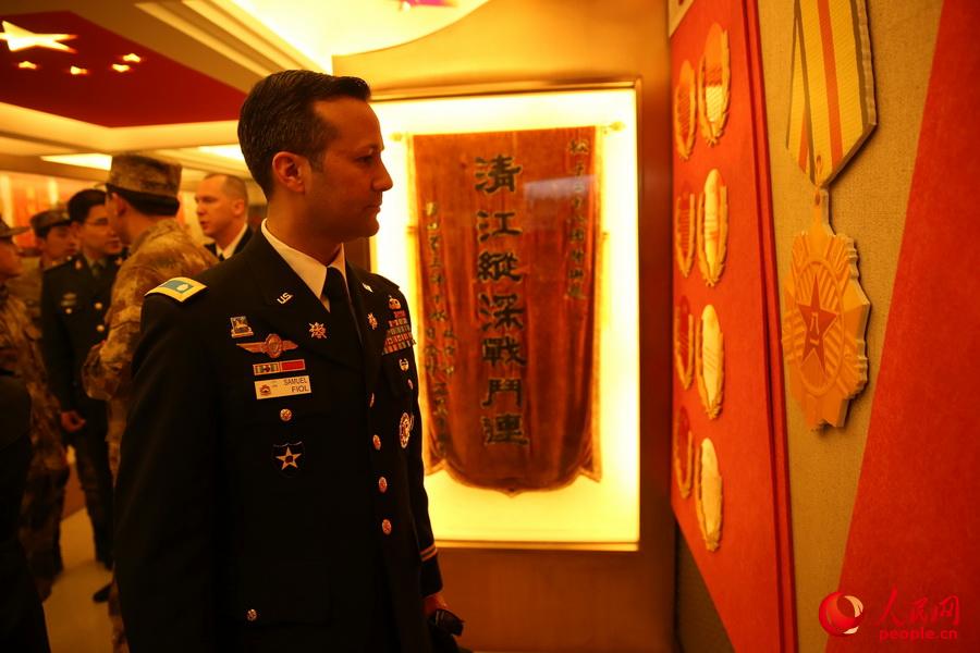 美軍代表在參觀該團“紅八連”榮譽室時觀看連隊榮譽牆。翟大帥攝
