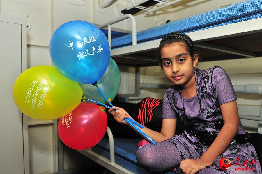 图为一名巴基斯坦小女孩手拿“中巴友谊、地久天长”的气球。熊利兵摄