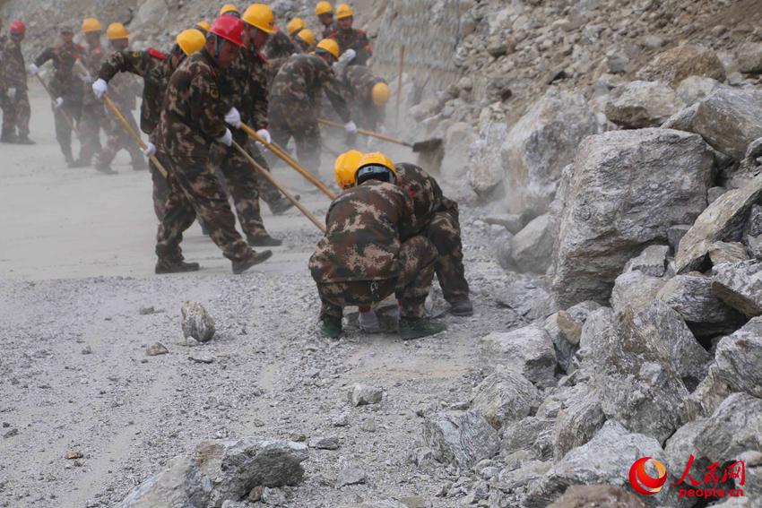 27日，武警交通第四支隊官兵正在塌方路段清理碎石。（季澤慶攝）