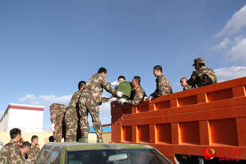 27日，武警交通第四支隊官兵正在裝運救災物資。（劉雨苗攝）