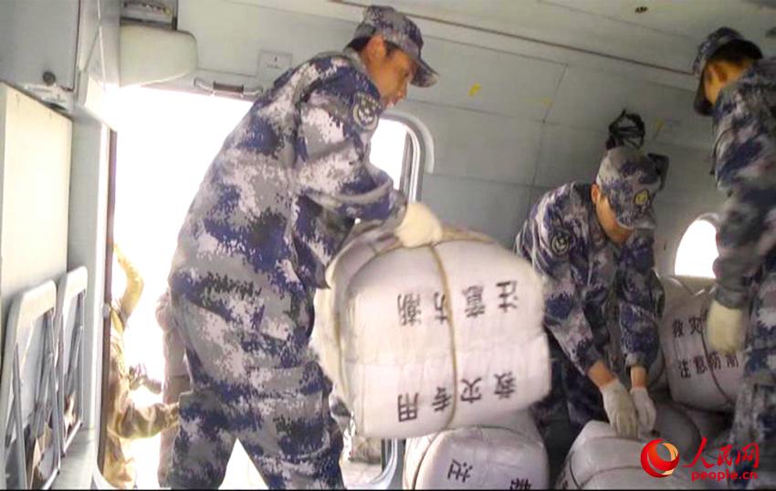 空軍某部組織應急分隊裝卸運送救災物資。