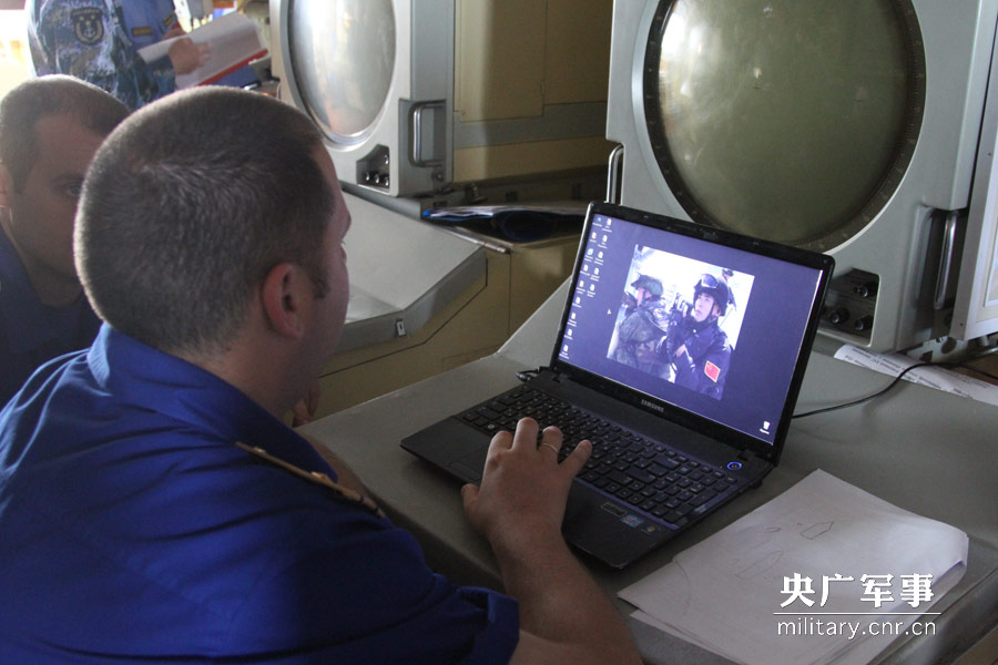  俄方艦員在欣賞中俄特戰隊員共同營救人質演習的照片