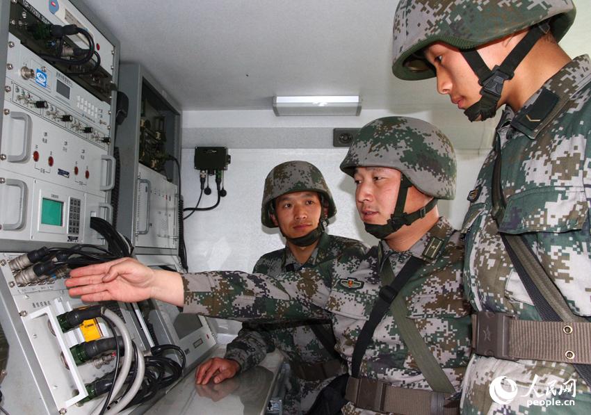 遠火營教導員王培成與指揮車人員研究如何提高射擊精度。陳輝攝