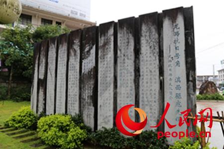 龍陵抗戰紀念廣場上反映龍潞區游擊支隊歷史功績的碑文。攝影：閆嘉琪