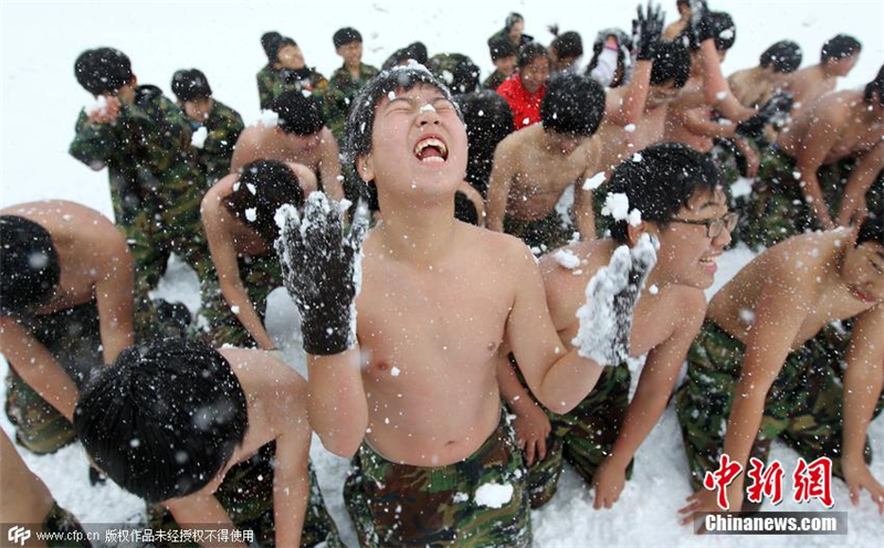 2010年12月27日，韓國安山島Daebu的新兵訓練營內，部分韓國中小學生赤膊在雪地中進行軍事訓練。