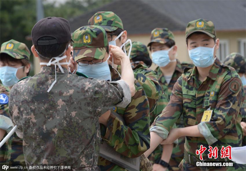 當地時間2015年6月5日，韓國京畿道，預備軍訓練基地中，教官為參訓學員佩戴口罩，測量體溫，預防中東呼吸綜合征。