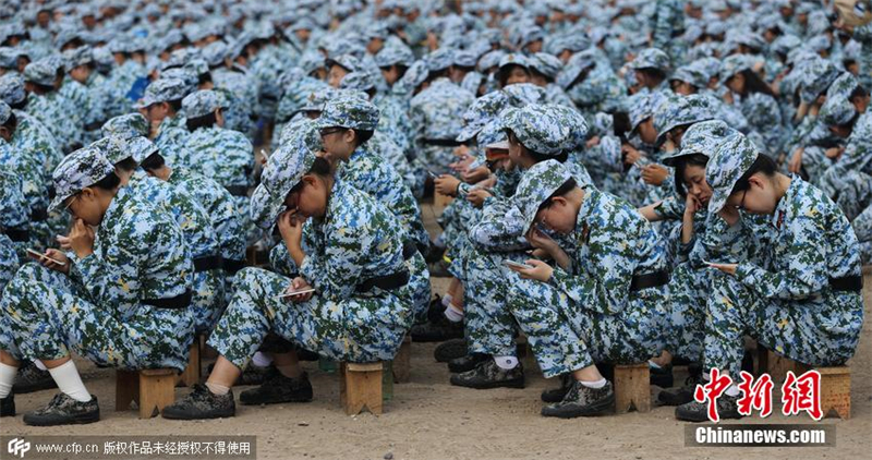 2015年8月25日，北京大學2015年學生軍訓團進行消防演練及體驗活動。學生化身“低頭族”玩手機，軍訓官也不例外。