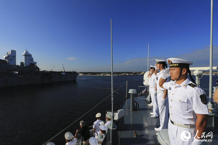 济南舰进港过程中，与美海军“硫磺岛”号两栖攻击舰舰面人员互相举手敬。代宗锋摄