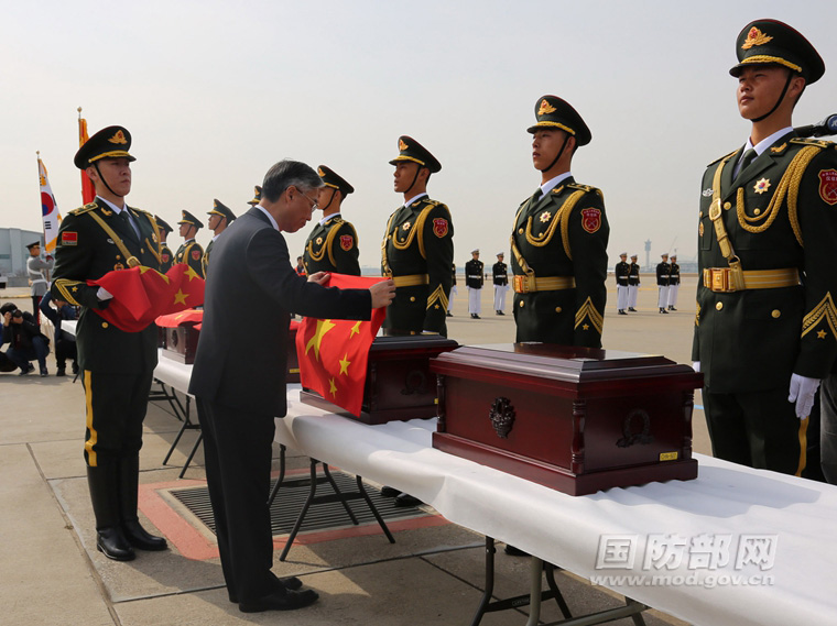 圖為中國駐韓國大使邱國洪為志願軍烈士遺骸覆蓋國旗。趙振 攝