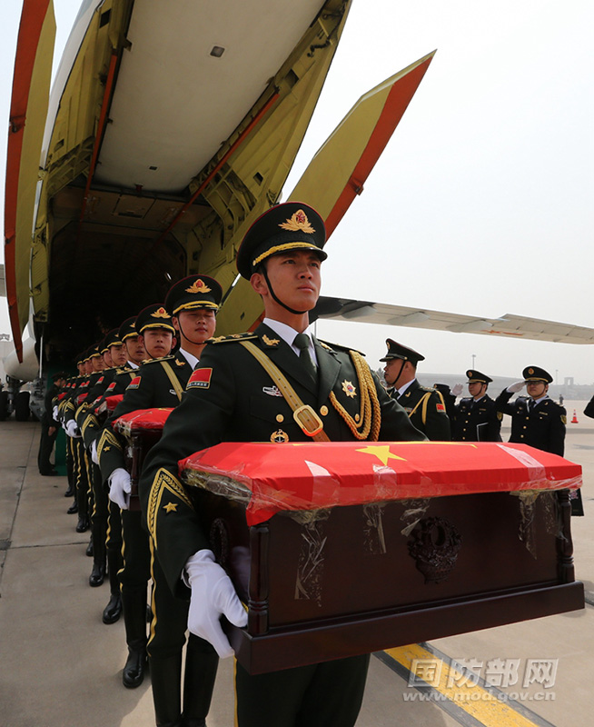 3月31日，禮兵將志願軍烈士遺骸棺槨運送出專機。穆可雙 攝