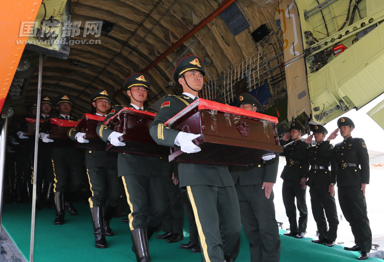 3月31日，禮兵將志願軍烈士遺骸棺槨運送出專機。穆可雙 攝