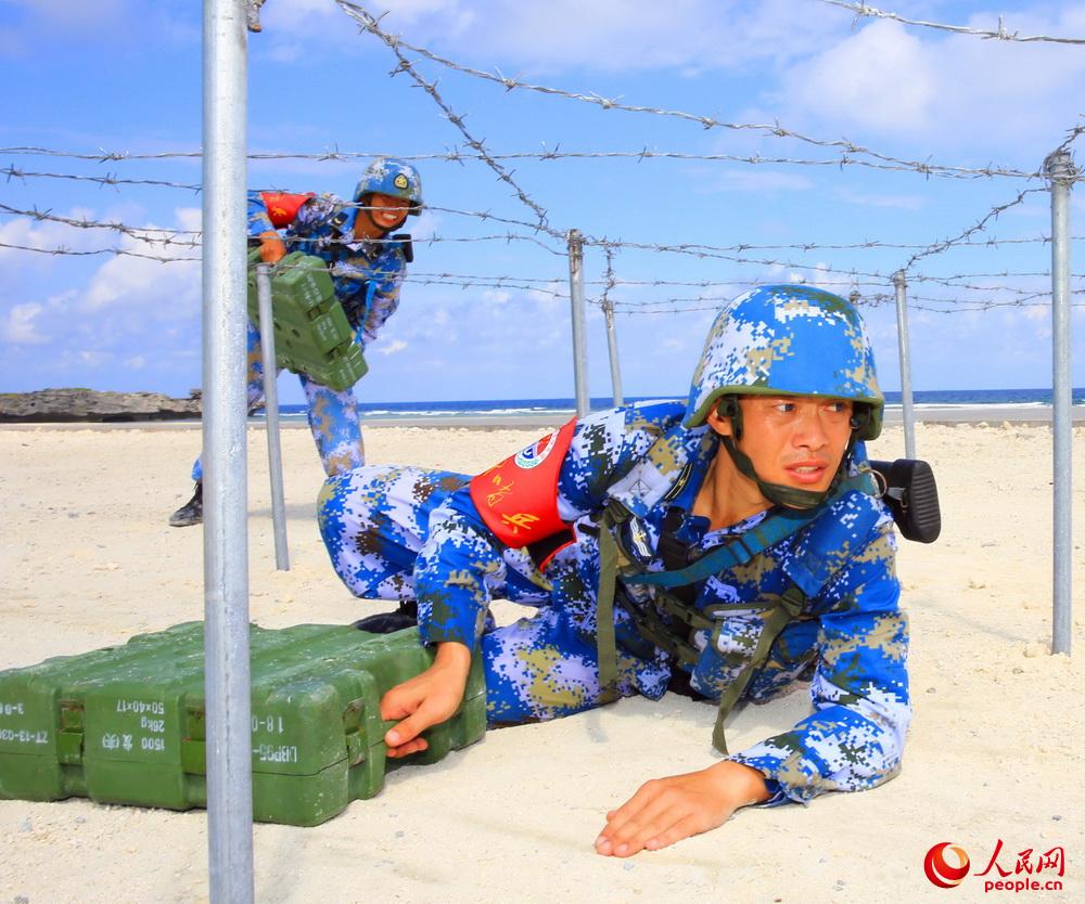 島上軍人攜帶彈藥箱進行穿越障礙訓練。夏錦 攝