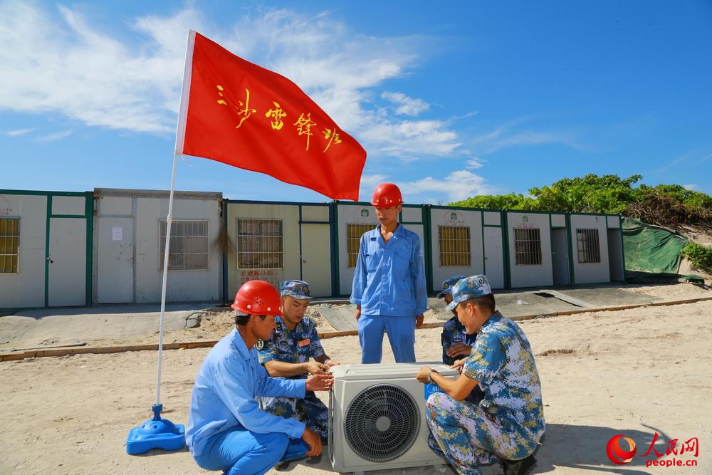 永興島上雷鋒班士兵為駐島工人義務維修空調。夏錦 攝
