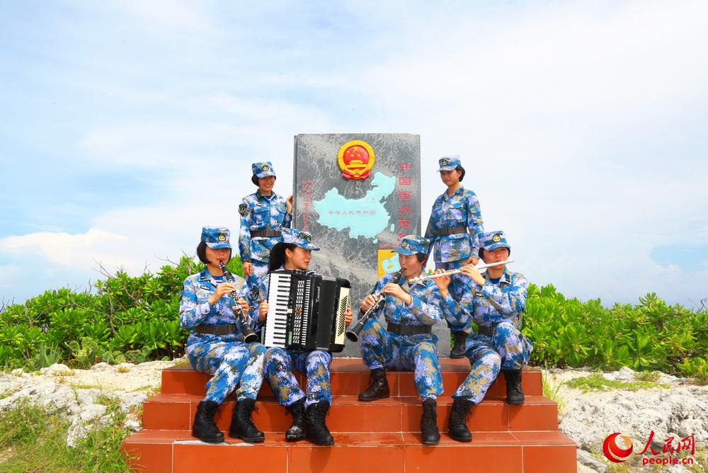 永興島上通信連女兵們在石島主權碑前演奏樂器。夏錦 攝
