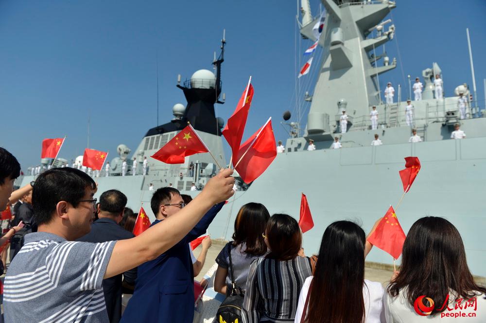 中資機構和華人華僑代表揮舞五星紅旗熱烈歡迎編隊到訪。張海龍攝