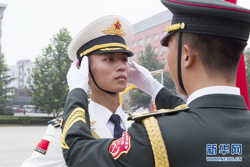   7月29日，中國人民解放軍陸海空三軍儀仗隊隊員劉俊強（右）在駐地為吳豪（左）整理軍容。 陳益宸攝