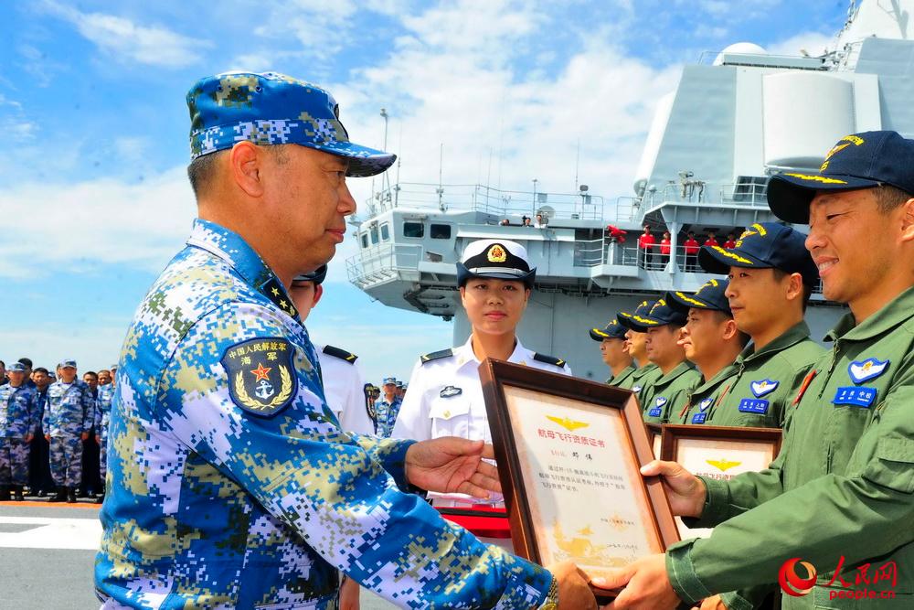 海军副司令丁毅中将为取得航母资质认证的舰载机飞行员颁发证书。张凯 摄影