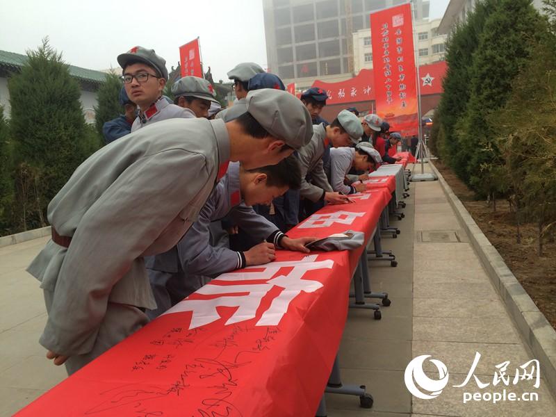 “保護紅色遺產·發展紅色旅游”萬人簽名儀式上，身著紅軍服飾的群眾正在簽名。柴秋實 攝