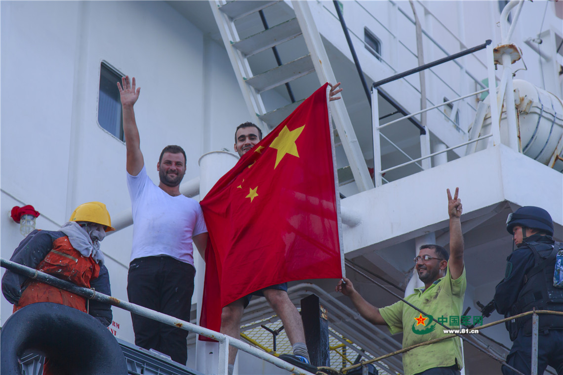 中國海軍第25批護航編隊玉林艦安全解護貨船“OS35”。圖為船員興奮地舉起五星紅旗表示感激。李維攝