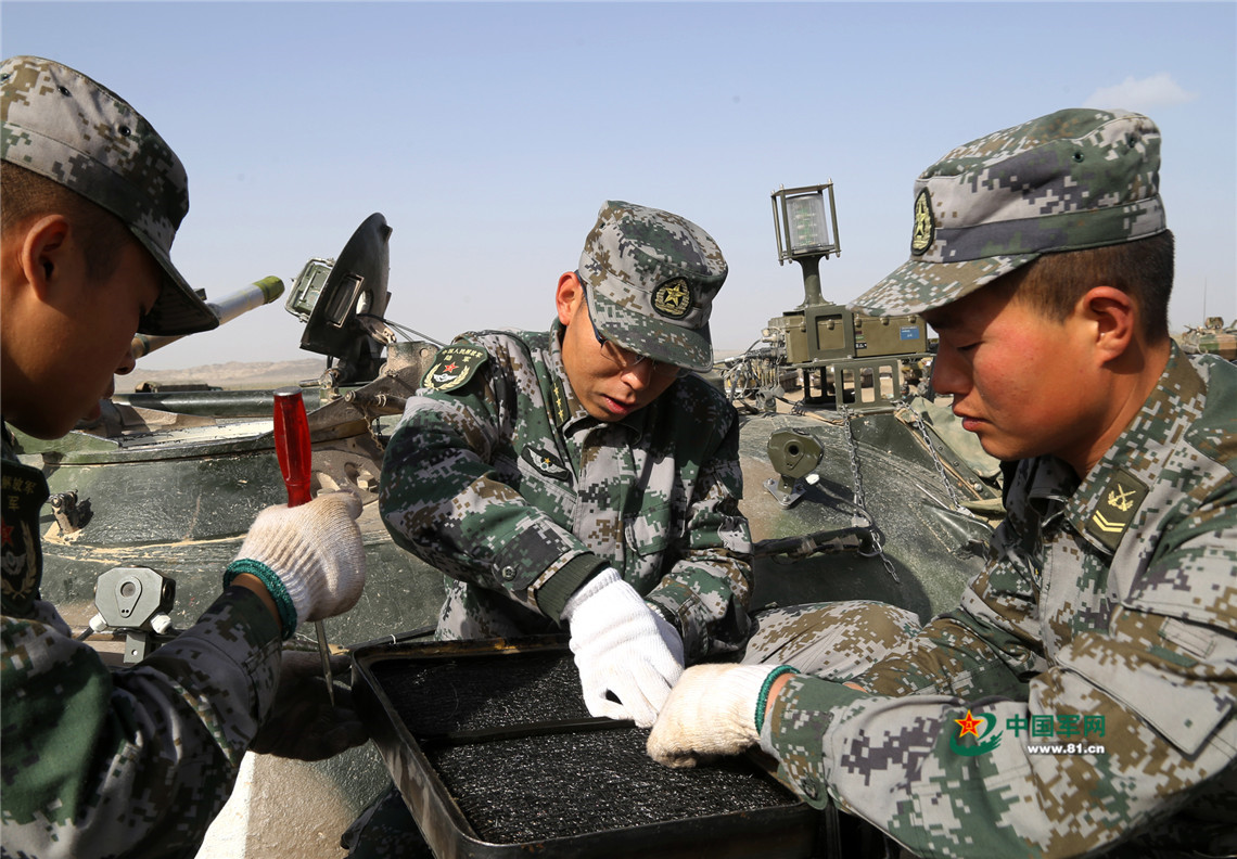 連隊指導員蔣慶斌（中）與戰士一起保養裝備。