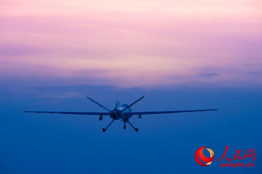 披著霞光  ，中國無人機從戈壁大漠大起飛 。楊軍攝影