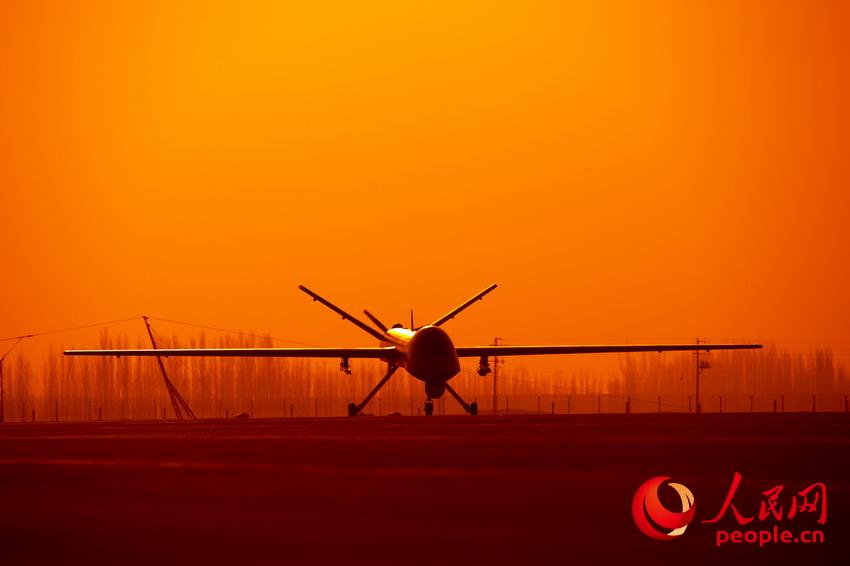 披著霞光，中國無人機從戈壁大漠大起飛 。楊軍攝影