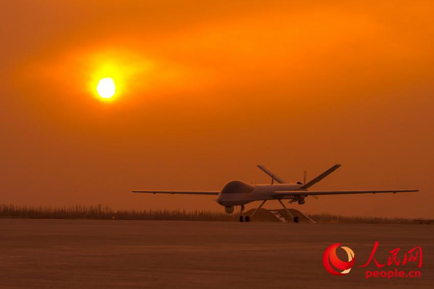 披著霞光，中國無人機從戈壁大漠大起飛。    楊軍攝影