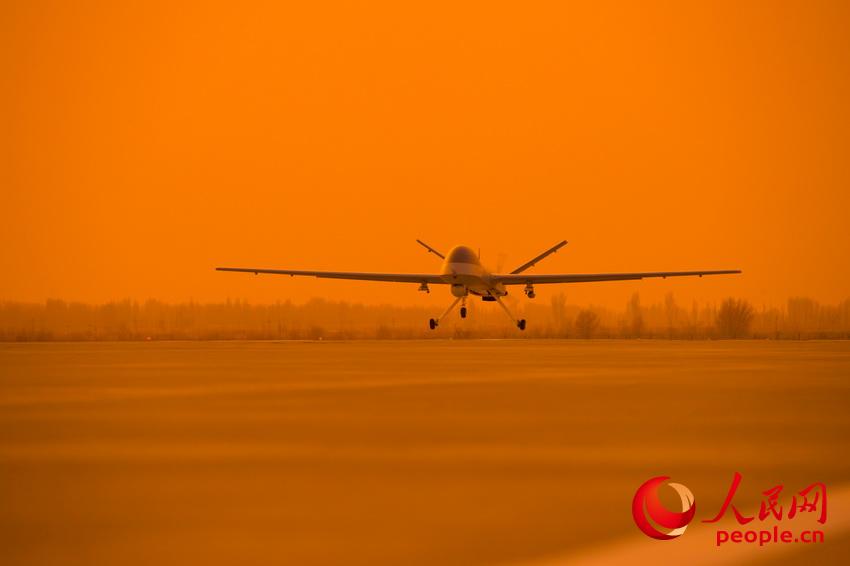 披著霞光，中國無人機從戈壁大漠大起飛。   楊軍攝影