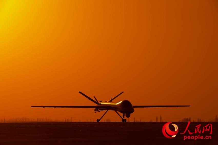 披著霞光，中國無人機從戈壁大漠大起飛。  楊軍攝影