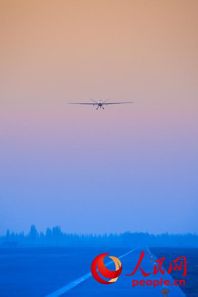 披著霞光，中國無人機從戈壁大漠大起飛。楊軍 攝影