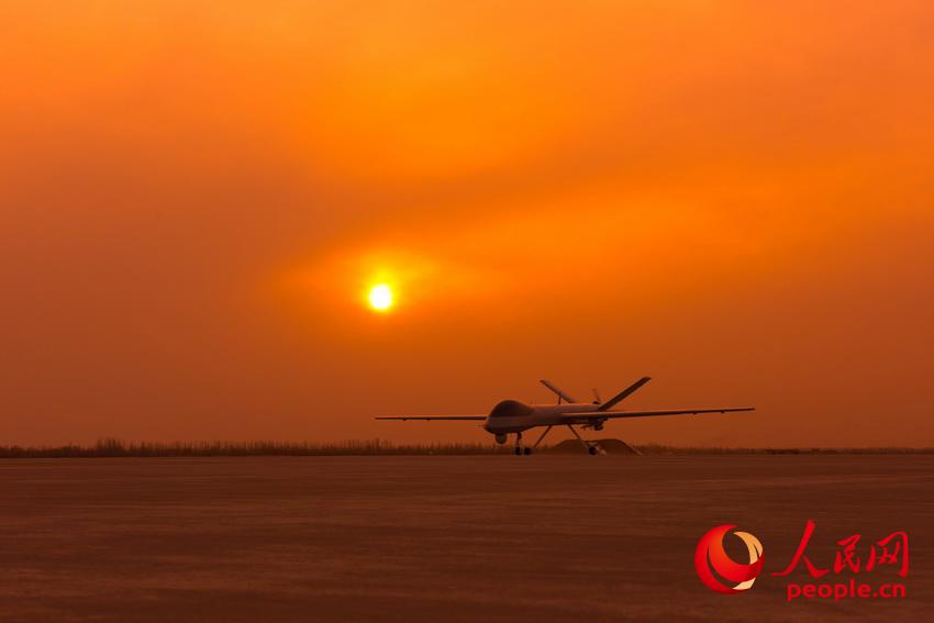 披著霞光，中國無人機從戈壁大漠大起飛。楊軍攝影
