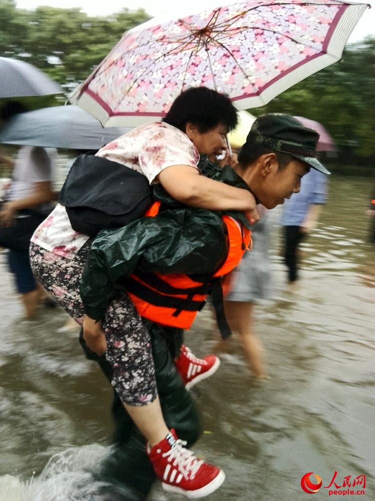 武警北京總隊官兵幫助行動不便的行人通過復雜水路段。焦一鳴攝