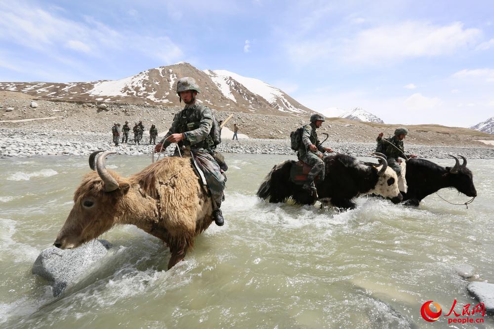 紅其拉甫邊防連官兵執勤中騎牦牛過冰河。
