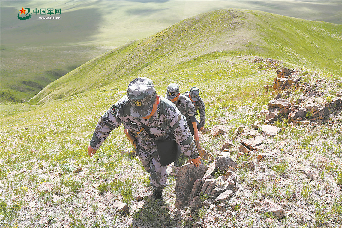 巡邏官兵攀行在陡峭的山脊上。
