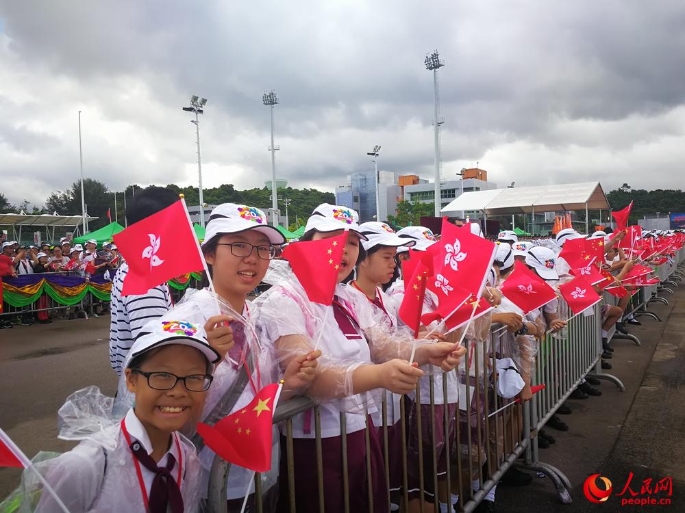 不少香港学生手持国旗和区旗欢迎“辽宁号”航母编队抵港。李华敏 摄