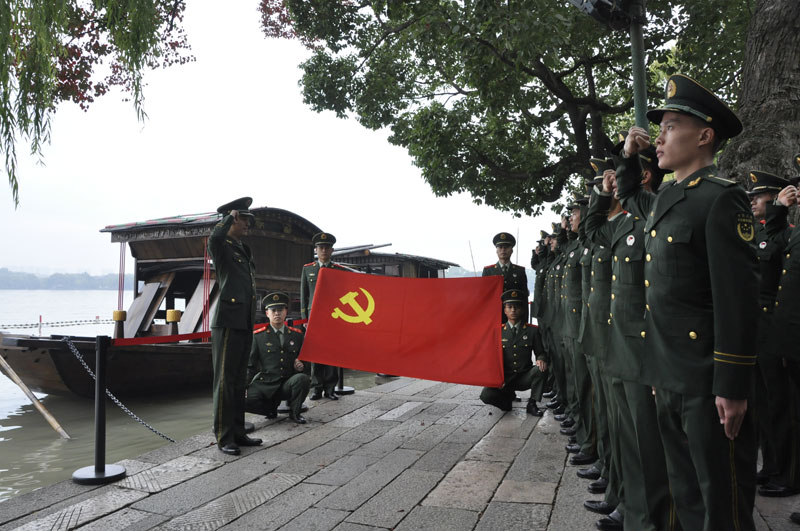武警桐鄉中隊的部分黨員戰士在南湖紅船邊重溫入黨誓詞。