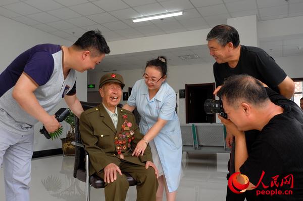 組織軍休干部攝影愛好者為光榮院老兵拍紀念照。