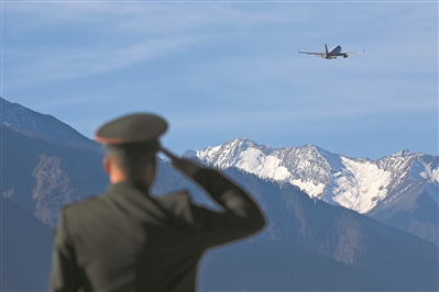 12月19日，西藏林芝米林机场，西藏军区某旅官兵遥望飞越雪山的民航客机，敬军礼为战友送行。王　　昊摄