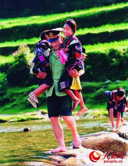 1999年，因白雲鄉漲水，何方禮背孩子過河。