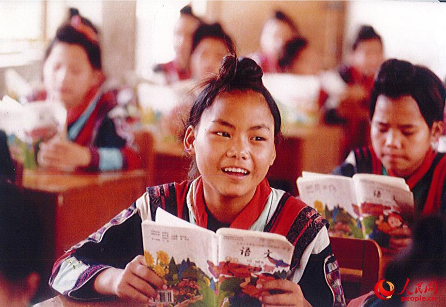 1997年，紅瑤女童走進學堂，拿起課本讀書。
