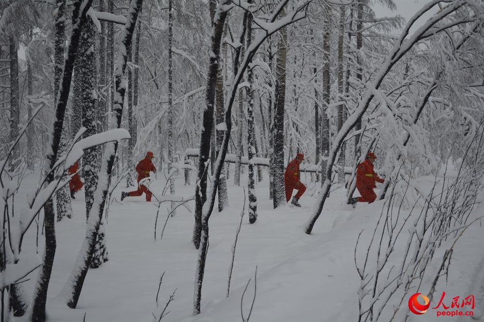 2017年“5·2”特大森林火災扑救中，4名戰友於大雪之中發現了還在冒煙的一處火點，於是飛奔前往處理。（伍笑印 攝）