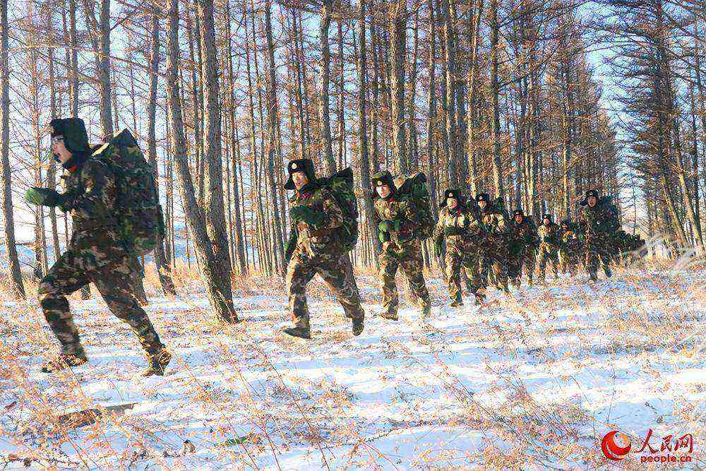 武警通遼市森林支隊野外拉練途中進行負重強行軍課目。