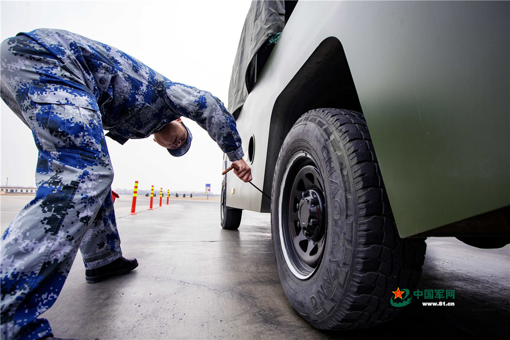 運輸股戰士檢查進場車輛輪胎防止帶入雜物。孫振東 攝