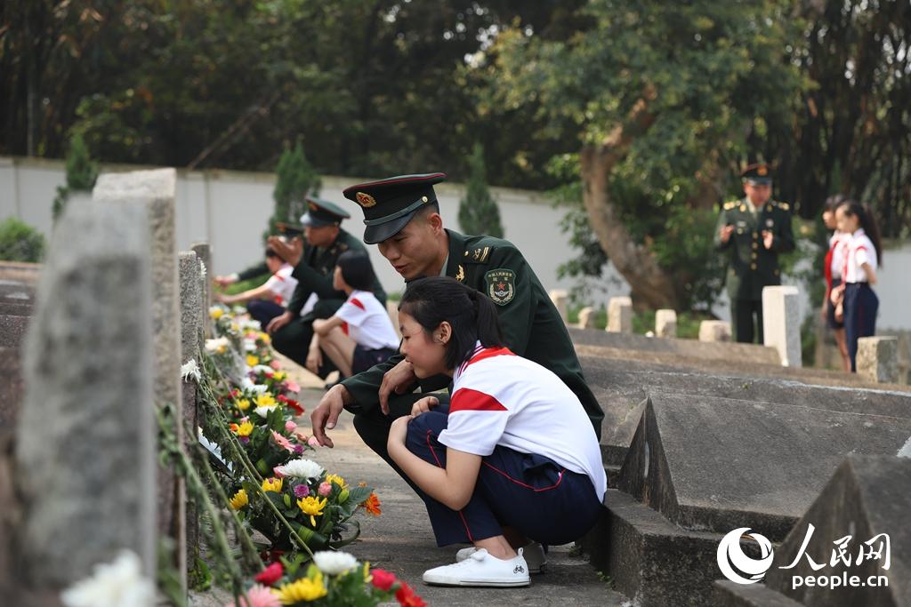 2018年4月3日，東部戰區陸軍合成某旅官兵在烈士墓碑前給駐地師生講述革命英雄光榮事跡。謝文劍 攝