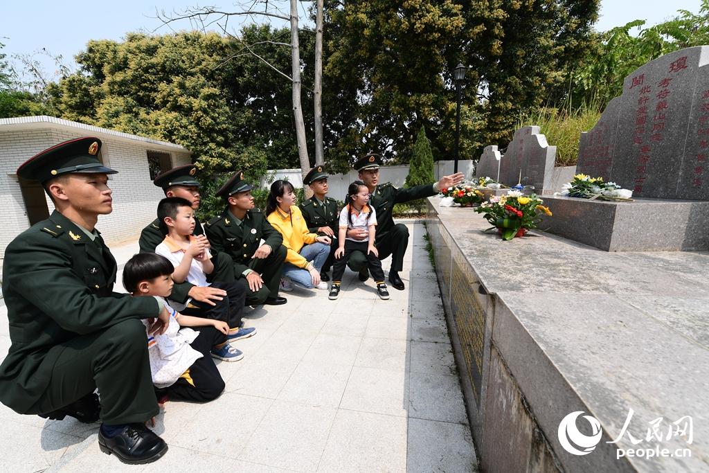 2018年4月3日，東部戰區陸軍合成某旅警衛勤務連官兵在合葬墓前給官兵和駐地幼兒園的老師、小朋友講述革命伉儷故事。賴橋泉 攝