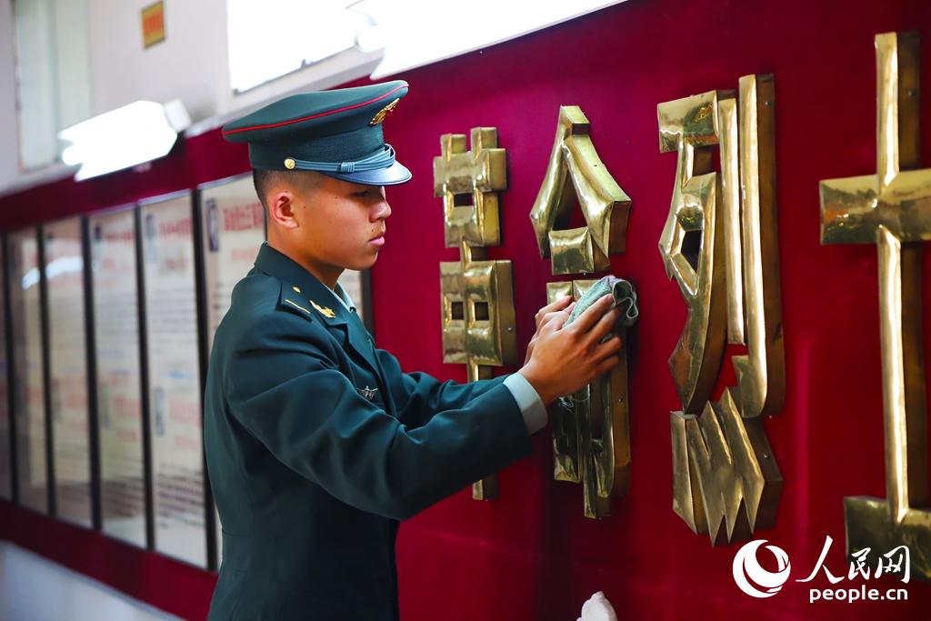2018年4月3日，東部戰區陸軍合成某旅警衛勤務連戰士楊帆擦拭烈士紀念牆。王路加 攝