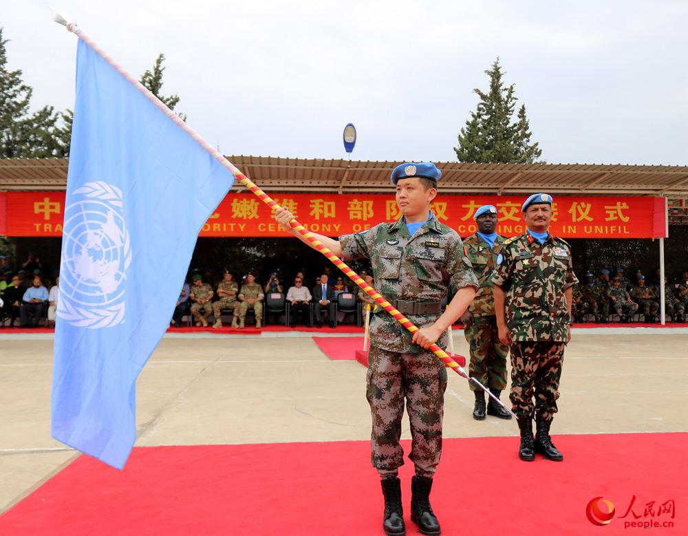 第17批赴黎維和部隊指揮長石鴻輝接過聯合國旗，同時接過維護和平的使命。（董永康攝）