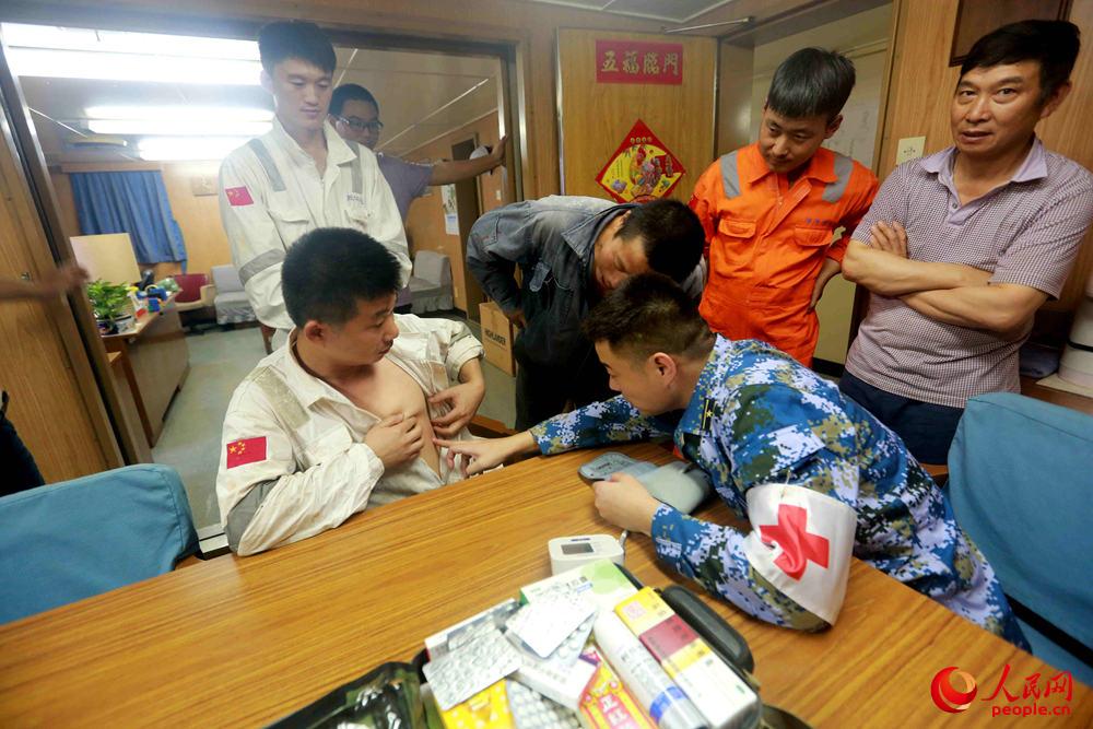 徐州艦軍醫為中國籍貨船振華25船員檢查身體。 張千 攝