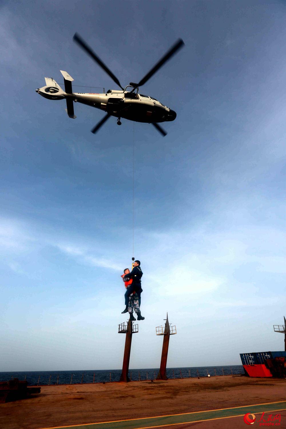 徐州艦直升機將人員吊放至振華25。 張千 攝